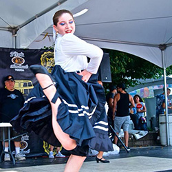 Thumbnail photo of Girl dancing in blue skirt with one leg up