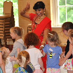 Thumbnail photo of Woman in red with a group of children