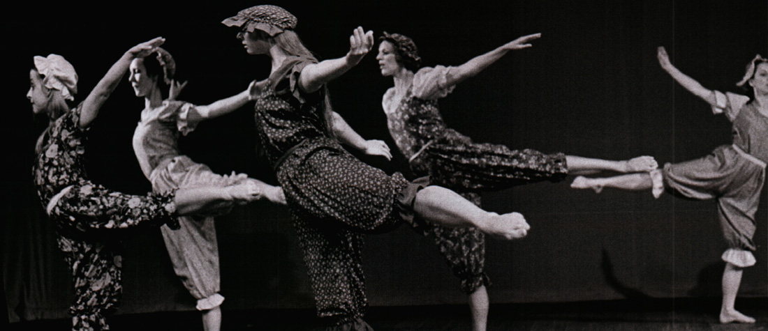 Five dancers on stage with arms and leg in the air
