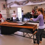 Thumbnail of Two people on either side of an instrument with others observing