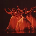 Thumbnail of Five dancers on stage facing the back of the stage wearing long dresses