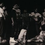 Thumbnail of Nine dancers gathered together, two sitting on the ground