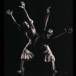 Thumbnail of Two dancers with knees bent and arms in the air
