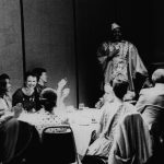 Thumbnail of group seated man standing speaking