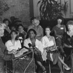 Thumbnail of group seated woman speaking