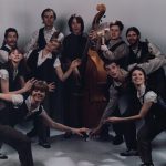 Thumbnail of group of people posing some with instruments