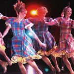Thumbnail of four dancers in bright dresses in air