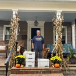 Thumbnail of Woman standing on a porch behind many boxes