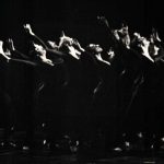Thumbnail of group of dancers on stage arms reaching up and back