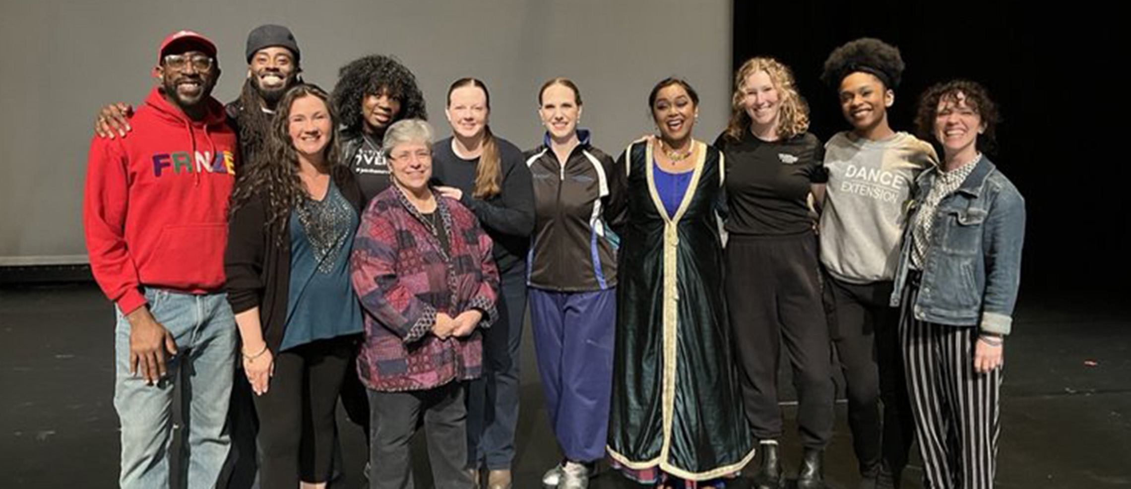 group of dancers smiling on stage