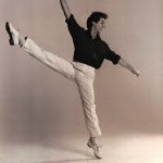 Thumbnail of Man dancing in white pants and dark top one leg in air