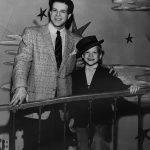 Thumbnail of Man standing with boy with a hat